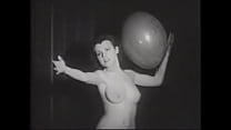 Erotic retro model with a beautiful figure plays with balloons for the crowd on stage