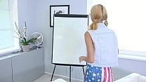 Cameraman shoots a blonde in glasses writing on the white board