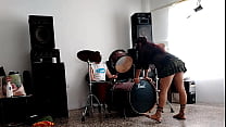 They play the drums for her she dances stripping and showing her ass